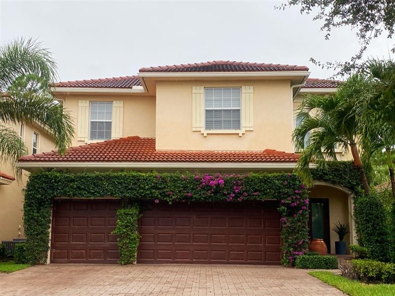 Terracotta stucco home with refinished dark garage doors