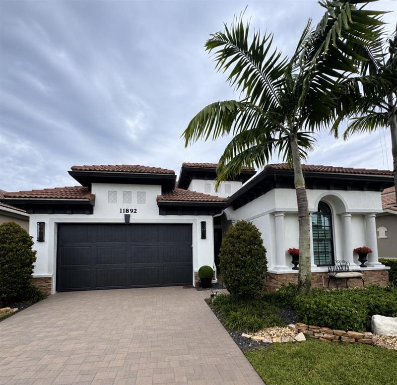 Single-story Palm Beach County home finished in bright white stucco with black trim